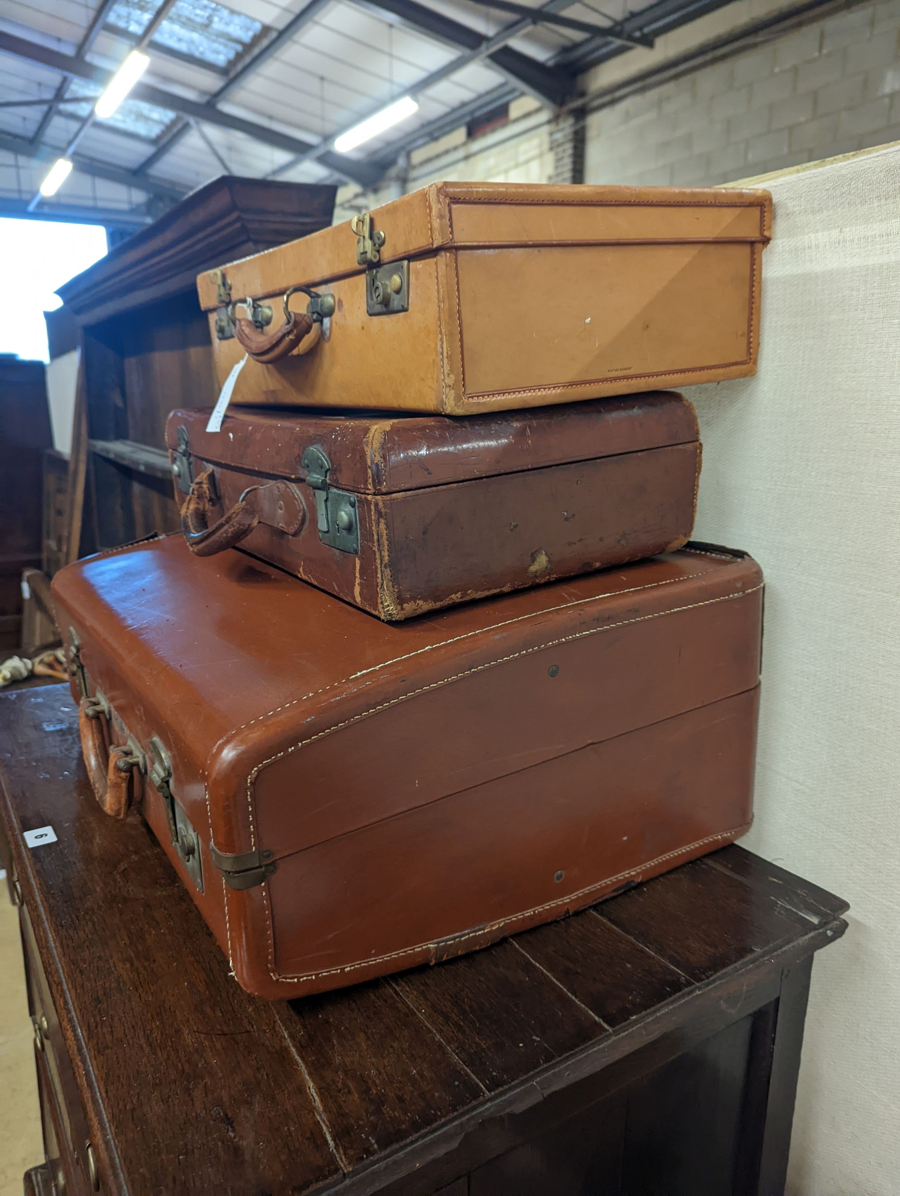 A vintage tan leather case, marked 'Tom Hill SW1' together with two other vintage cases, largest width 61cm, depth 46cm